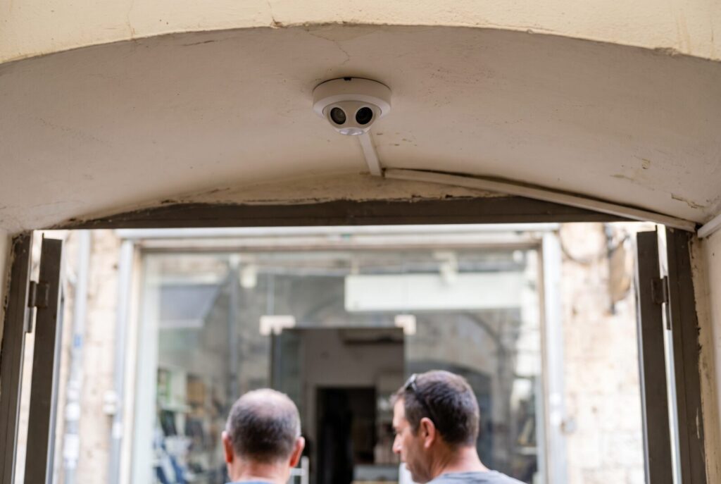 Ceiling-mounted people counter sensor above a store entrance