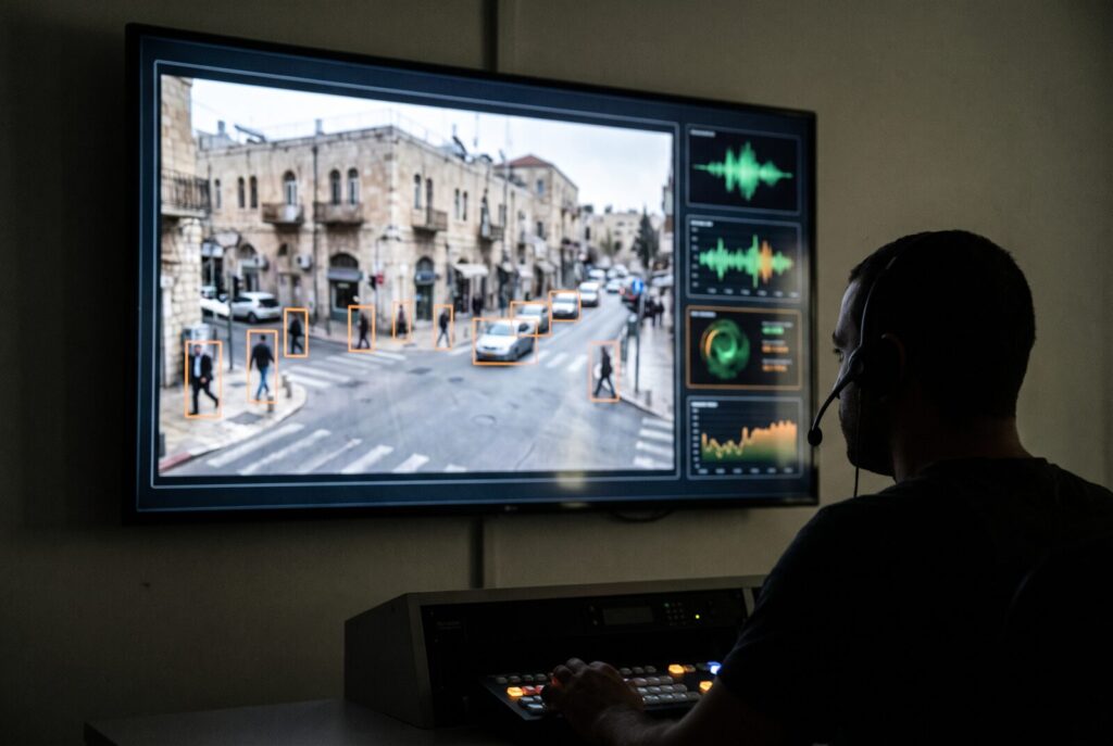 Control room monitor showing video analytics bounding boxes around people and vehicles